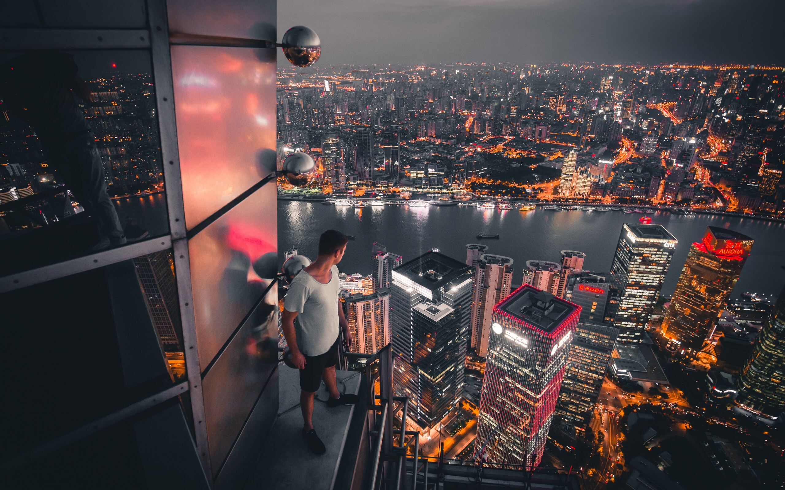 boy-standing-on-the-rooftop-of-building-looking-down-5k-ao-2560x1600.jpg
