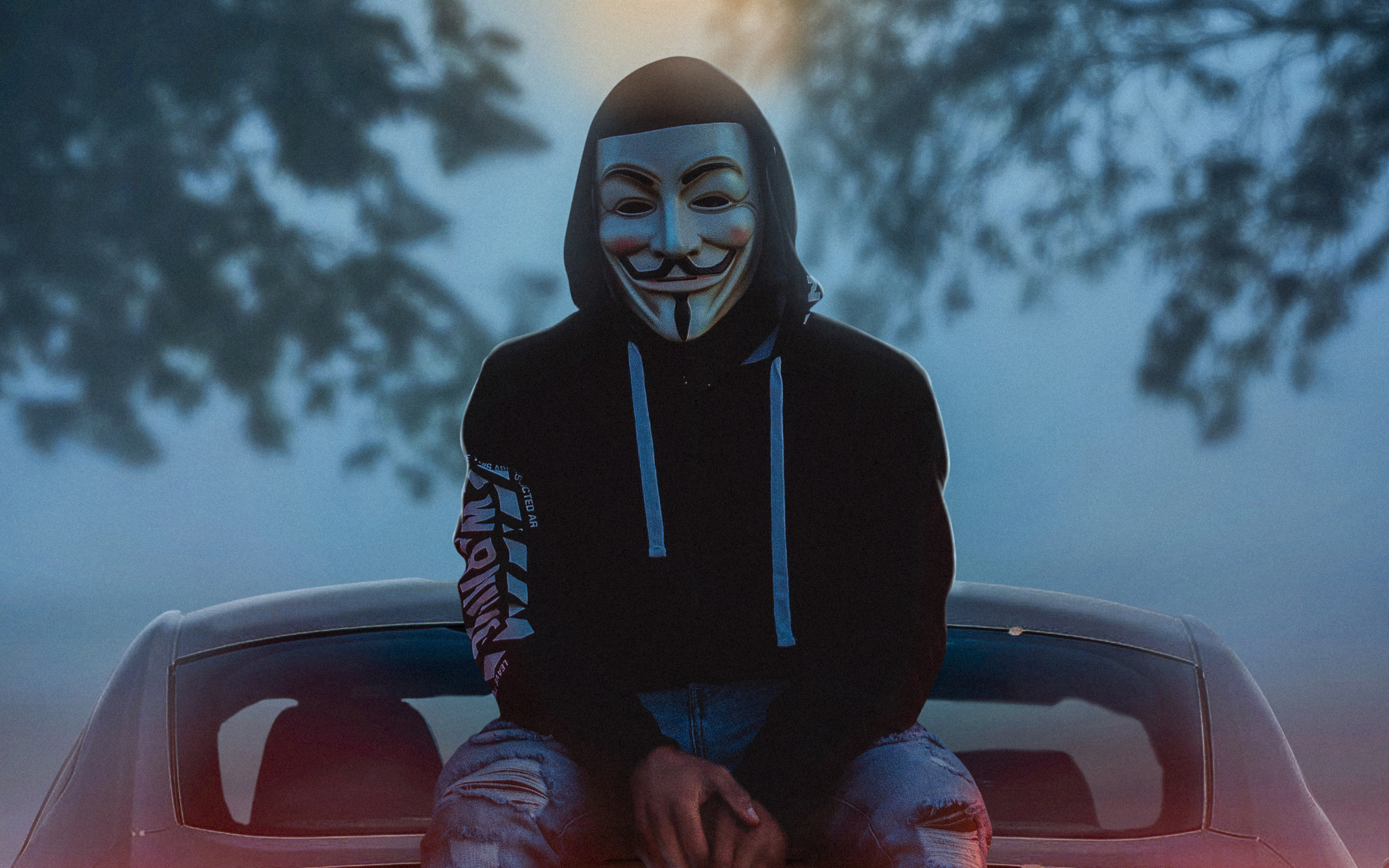 man-wearing-guy-fawkes-mask-while-sitting-on-car-4k-jw-2560x1600.jpg
