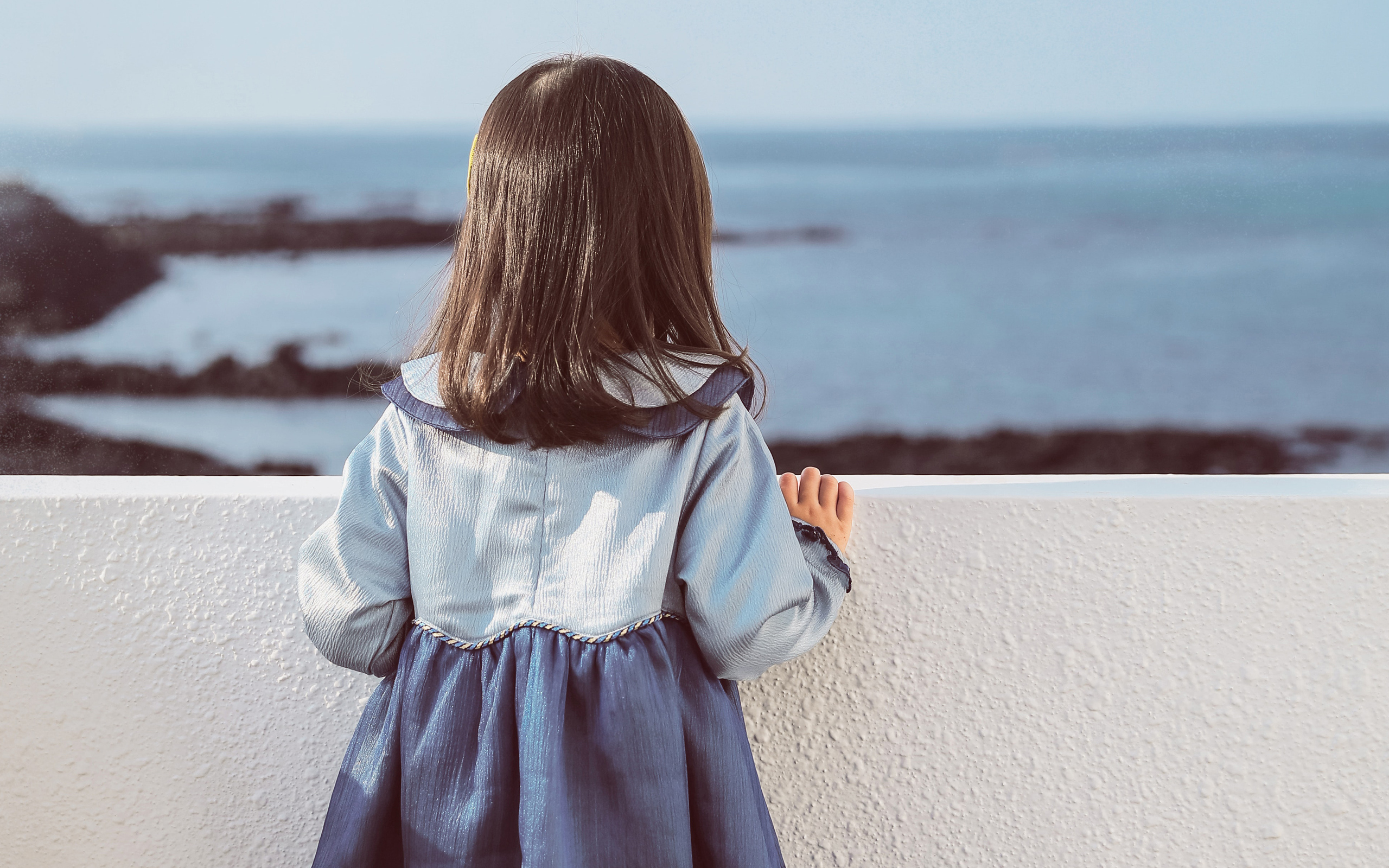 liitle-girl-holding-on-white-concrete-fence-ni-2560x1600.jpg